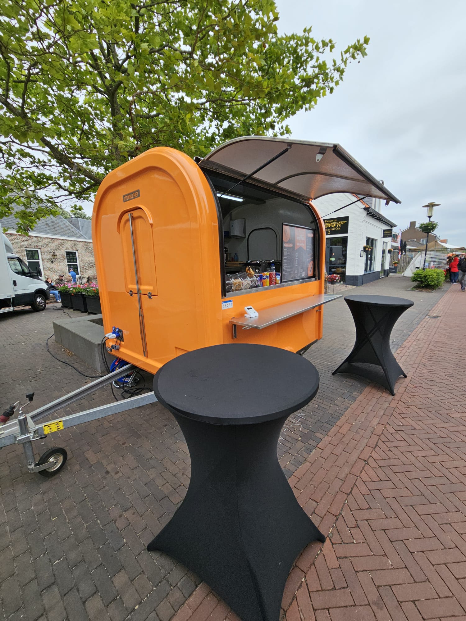 Portable food truck with outdoor seating area on a street
